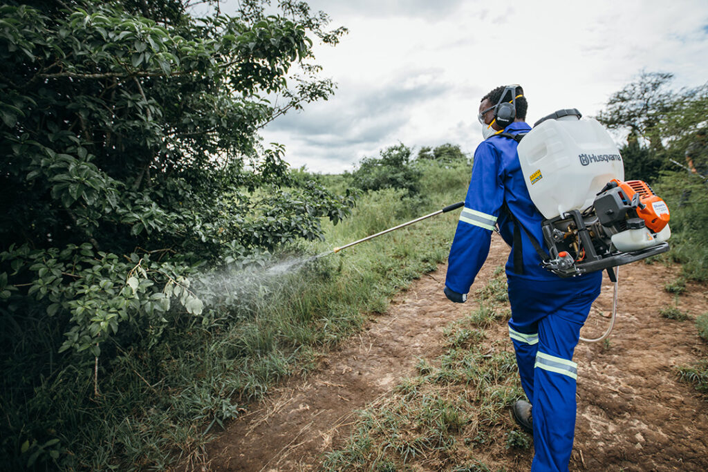 A man sprays a tree with a Husqvarna sprayer in Zimbabwe.