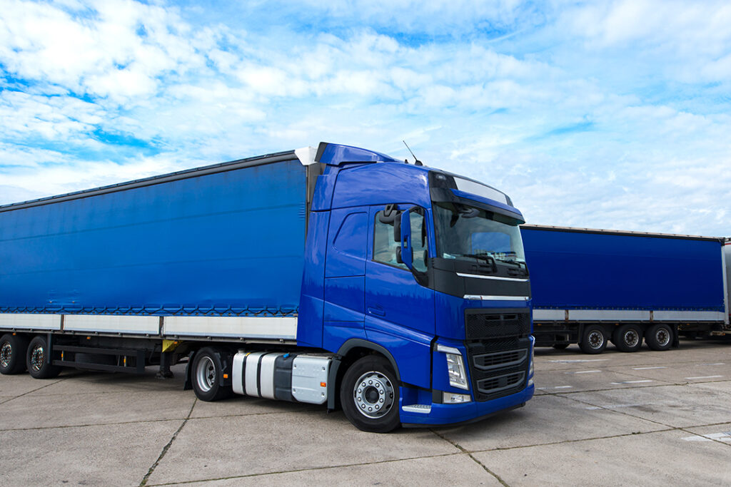 A blue lorry parked inside a logistics yard.