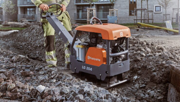 A Husqvarna LG 204 plat compaction machine on rough rocks.