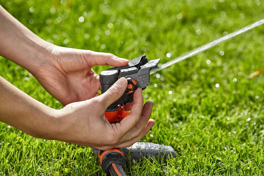 A GARDENA Pulse Sprinkler being adjusted by the owner.
