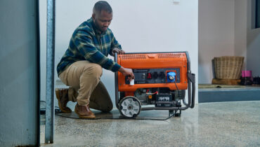 A man turning on his Husqvarna G8500P generator inside his garage.