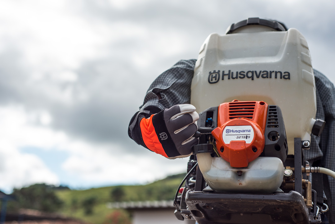 a man wearing a husqvarna 325s25 sprayer for tobacco