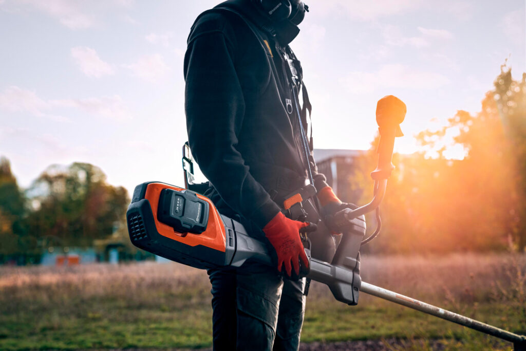 A battery-powered Husqvarna brushcutter at sunset