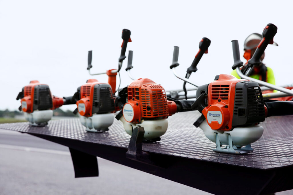 Four Husqvarna brushcutters on the back of a trailer.